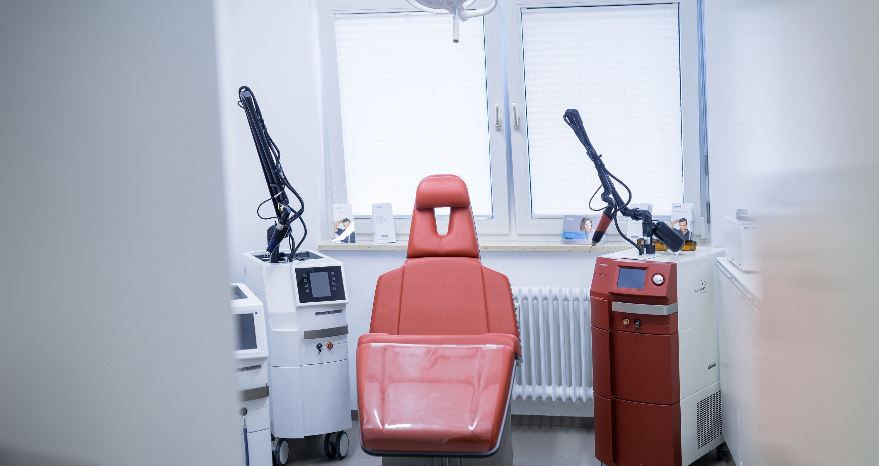 Blick in ein Behandlungszimmer mit Stuhl und dermatologischen Geräten